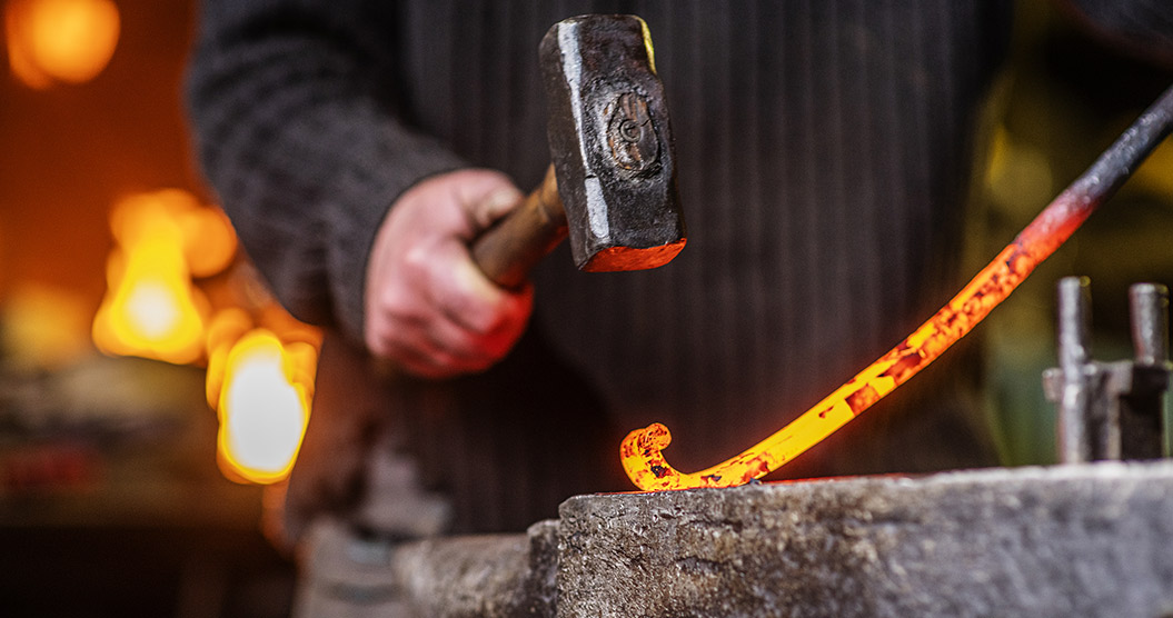 Schmied mit Hammer bei der Arbeit
